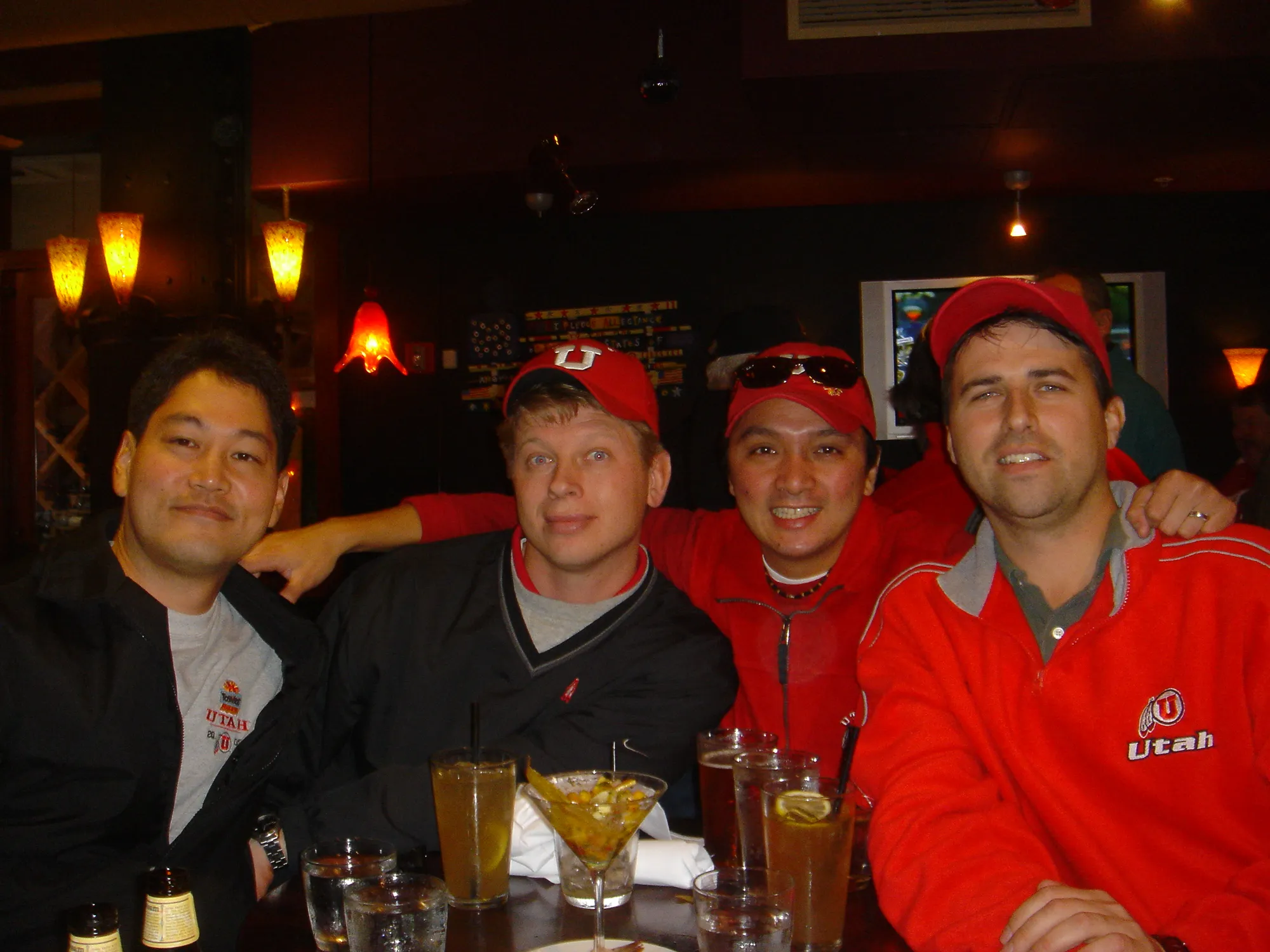 Four friends in Utah gear around a table after the game