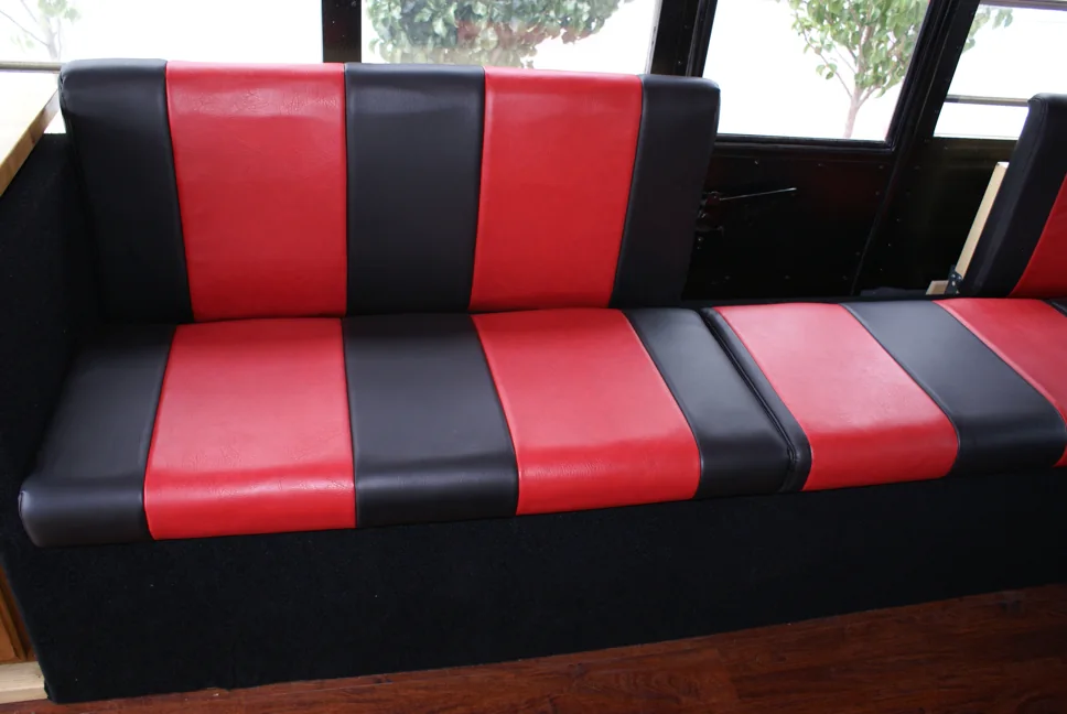 A finished red and black striped bench seat beside the windows