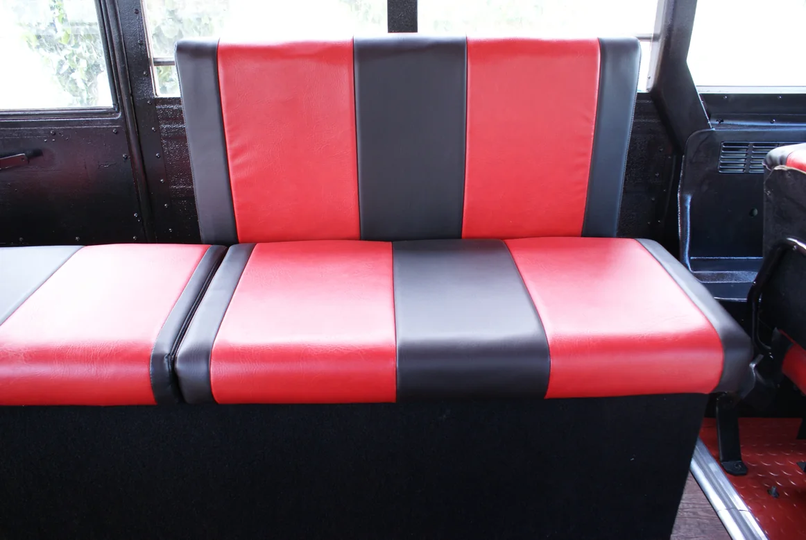 A red and black bench seat behind the driver area