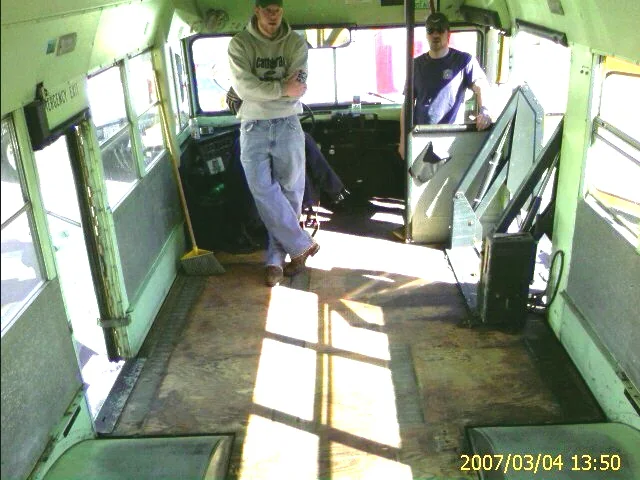 Crew members stripping the old school-bus seats and flooring out of the bus