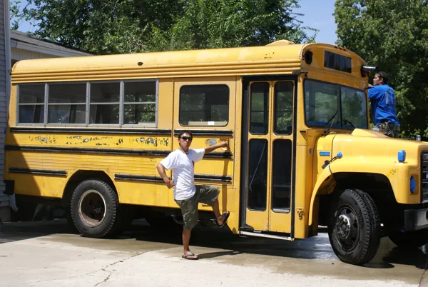 The yellow bus at the house, being sanded and taped for paint
