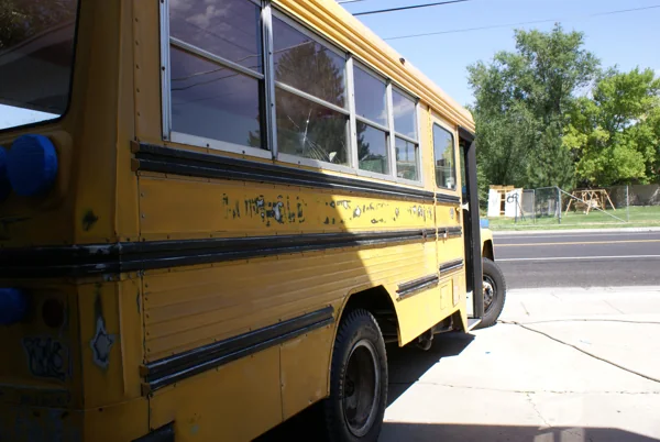The yellow bus at the house, being sanded and taped for paint