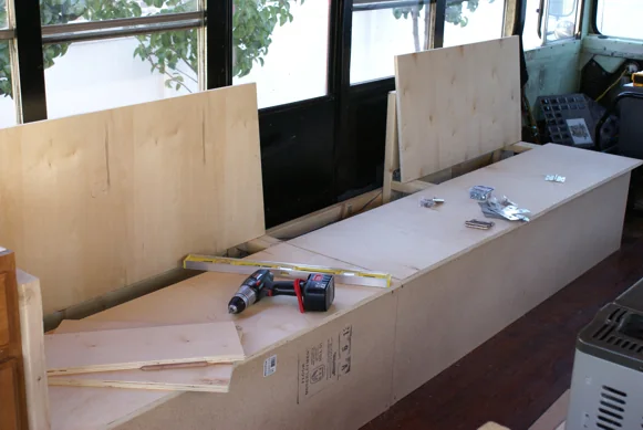 Bench and cabinet frames being built inside the stripped-out bus