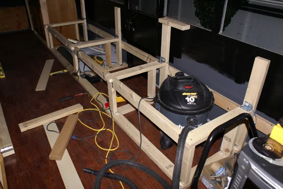Bench and cabinet frames being built inside the stripped-out bus