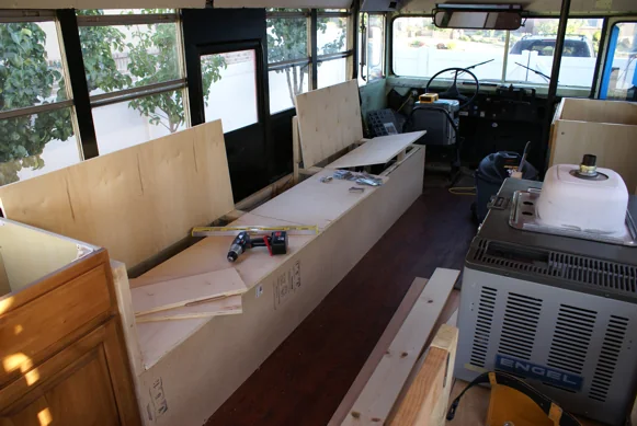 Bench and cabinet frames being built inside the stripped-out bus