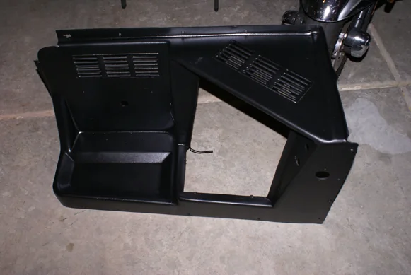 The engine cover, freshly painted black, waiting to go back in