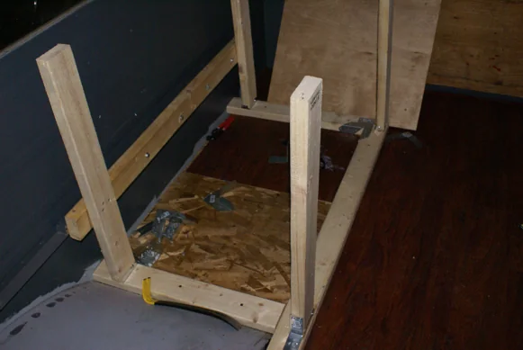 Bench and cabinet frames being built inside the stripped-out bus