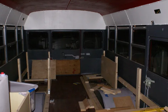 Bench and cabinet frames being built inside the stripped-out bus