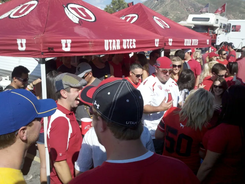 A packed tailgate crowd under Utah Utes canopies
