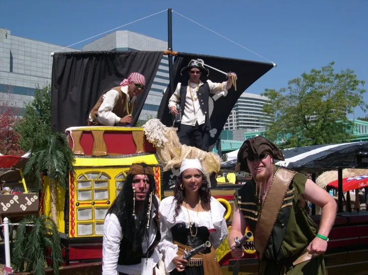 The crew in pirate costumes around their pirate ship flying machine