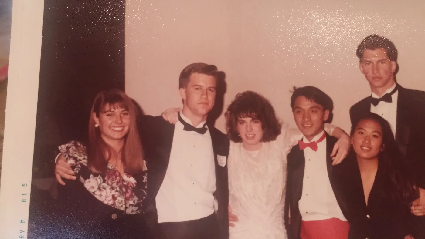 An old photo of brothers in tuxedos with their dates at a formal