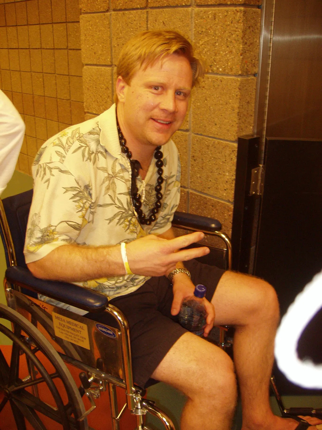 A friend in a Hawaiian shirt and leis lounging in a chair