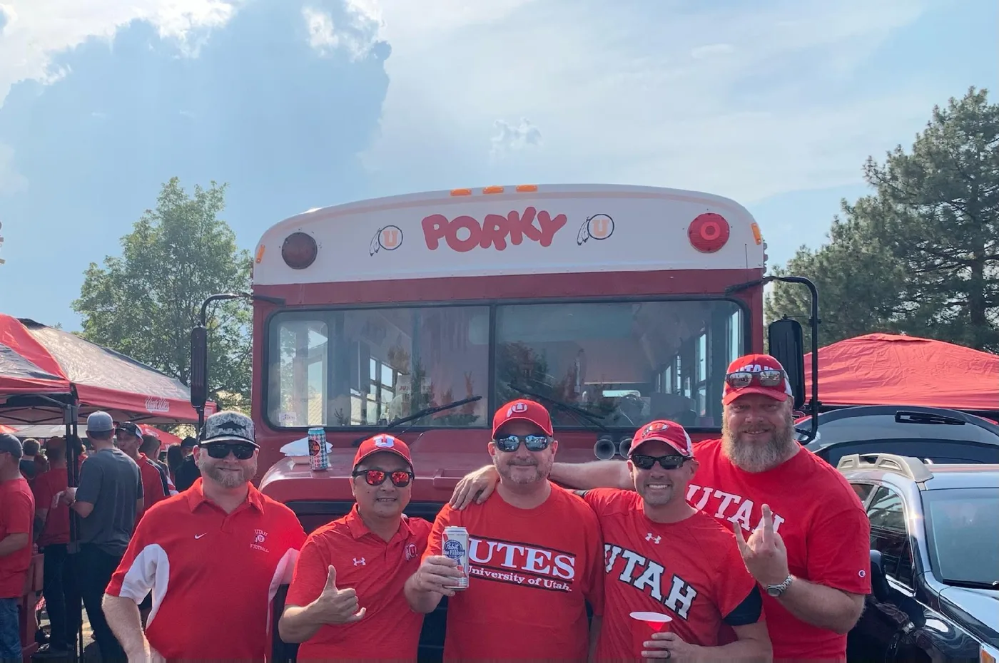 Five crew members in Utah red posing in front of Porky in the lot