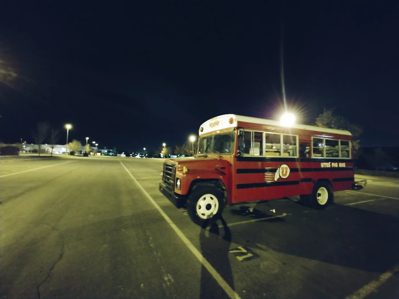 Porky parked alone in an empty lot at night under the lights