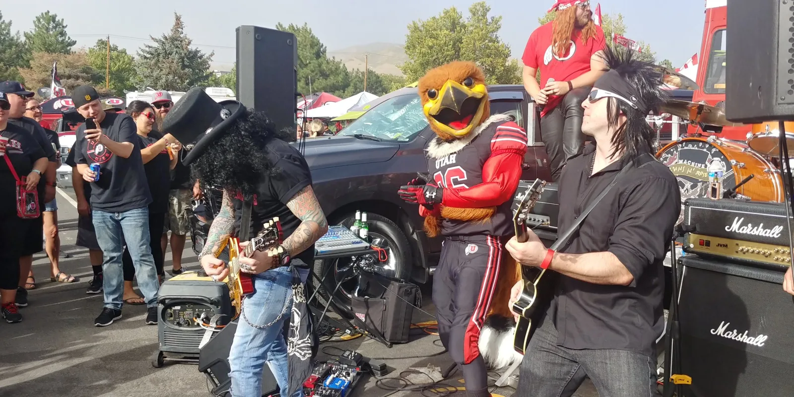Swoop dancing between two costumed guitarists playing in the tailgate lot as fans film